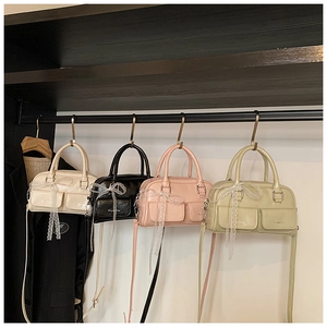 Close-up of Boston style bags in pastel colors with delicate lace bow decorations
