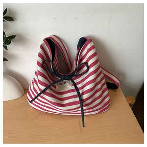 Close-up of red and white striped canvas tote bag with See You label and bow tie detail