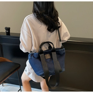 Détail du sac cabas en denim bleu foncé avec logo en cuir et poignées en toile noire