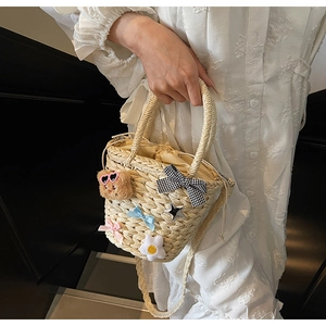 Détail du sac de plage en paille tissé main avec ours en peluche et ornements
