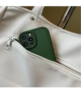 Detail of exterior zipper pocket on large canvas tote bag with a smartphone inside