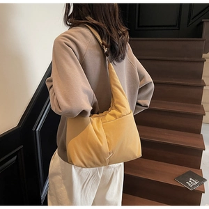 Detail of a mustard yellow padded tote bag on model showing cloud-like texture
