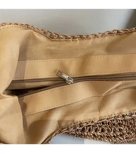 Détail de la doublure en tissu kaki et de la fermeture éclair en métal argenté du sac paille