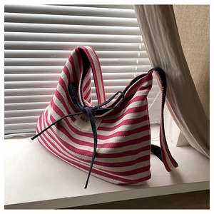 Close-up of red striped canvas tote bag with bow detail and 'SEE YOU' fabric patch