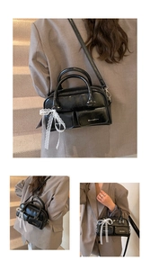 Detail of black glossy leather handbag with lace bows and external flap pockets