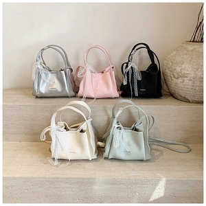 Litchi texture bucket bags in five colors with lace bow handles on stone stairs
