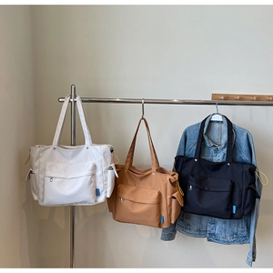 Detail showing high-capacity tote bags with side drawstring pockets and front zipper