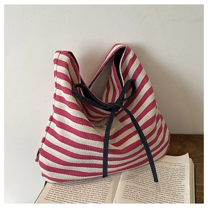 Close-up of the red and white striped canvas tote with a decorative black bow detail