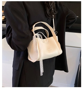 Close-up of off-white lychee leather bucket bag with elegant white lace ribbon detail