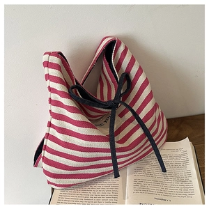 Close-up of red and white striped canvas tote bag with a decorative black bow tie
