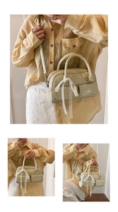 Detail of oil wax leather bowling bag with lace bow and dual front square pockets