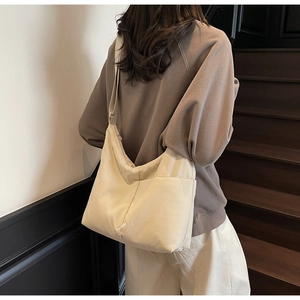 Detail view of cream white nylon hobo bag showing the wide adjustable shoulder strap