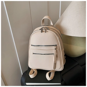 Detailed close-up of cream pebble-textured mini backpack with silver zipper pockets