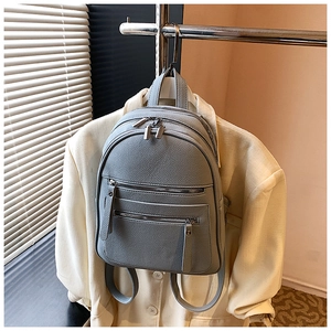 Detail of grey-blue litchi grain backpack with multi-layer zipper compartments