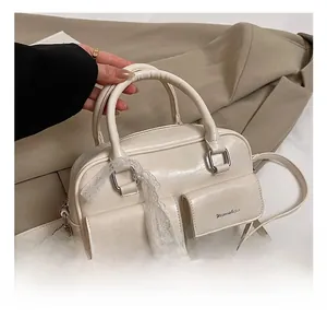 Detail of cream white handbag with lace ribbon decor and dual flap pockets
