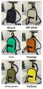Mini nylon backpack wallets in six colors with zippers and hooks on a desk