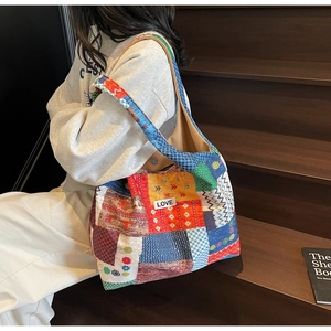 Detail van de patchwork canvas tas met kleurrijke patronen en een LOVE-tekstpatch