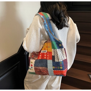 Detail van kleurrijke patchwork shopper met LOVE-label gedragen door een model