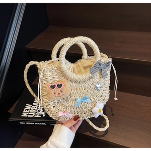 Détails du sac en paille tressée avec ours en peluche, nœuds et étoiles sur bois