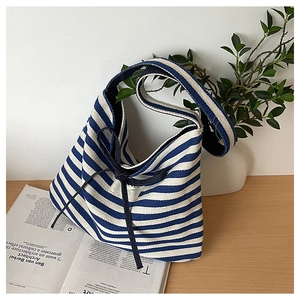 Detail of blue and white striped canvas tote bag featuring a decorative dark blue bow