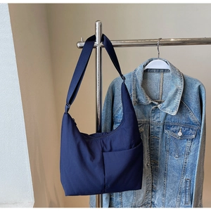 Detail view of the navy blue nylon hobo bag featuring an adjustable wide shoulder strap