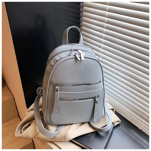 Close-up of light blue backpack featuring litchi texture leather and silver zippers