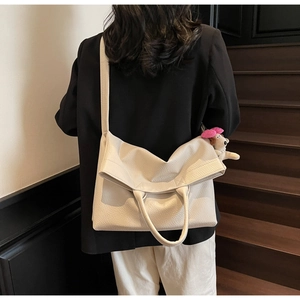 Modelo con bolso tote blanco crema en cuero granulado y colgante de perrito de felpa