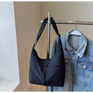 Detail of black nylon hobo bag with front pocket and adjustable wide strap