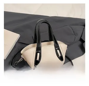 Detail of contrast color beige and black crossbody bag with top handle and fashion text