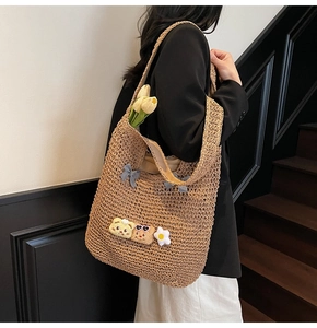 Détail du sac cabas en paille tissée avec nœud mignon, ours et fleurs décoratives