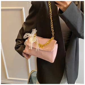 Pink rectangular leather bag with gold chain strap, lace bow and pearl charms detail