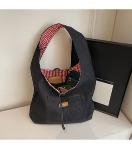 Detail of blue denim tote bag with red checkered lining and spacious interior storage