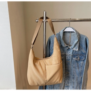 Detail shot of khaki nylon tote bag with adjustable strap and side pocket design