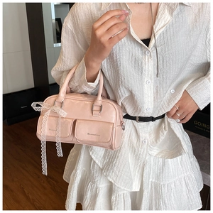 Detail of light pink shoulder bag with lace bow decoration and dual front pockets