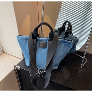 Détail du grand sac cabas en denim avec patch logo en cuir et bandoulières tissées
