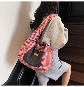 Detail of red gingham tote bag with denim pocket and drawstring closure on stairs