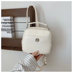 Dettaglio della mini borsa bianco sporco con logo rotondo e spalline regolabili