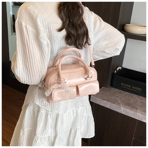 Pink PU leather handbag detail with dual small flap pockets and a white lace bow knot
