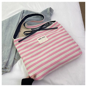 Detail of canvas tote with pink stripes, blue straps and See You text label