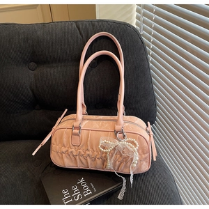 Detail of pink pleated cylinder bag featuring delicate pearl lace bow and marble texture