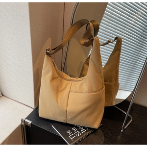 Detail of khaki nylon tote bag with wide adjustable strap and large front pocket