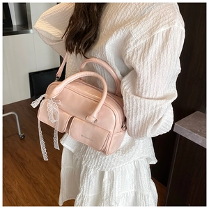 Detail of light pink oil wax leather bowling bag with lace strap and front pockets
