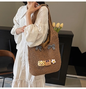 Détail du sac cabas en paille tissée avec nœuds vichy noirs et breloques ours