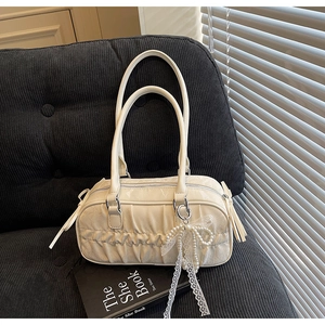 Detail of off-white pleated bag with pearl beads, lace bow and leather tassel accents