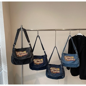 Multiple denim messenger bags in black and blue shades with vintage embroidery and wide straps