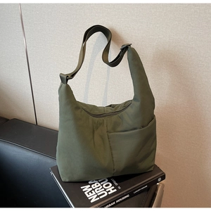Detail view of army green nylon hobo bag featuring adjustable wide strap and zipper pocket