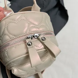 Détail des doubles fermetures éclair argentées et matelassage cœur sur le sac