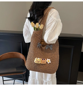 Détail du sac cabas en paille avec oursons en peluche et nœuds à carreaux