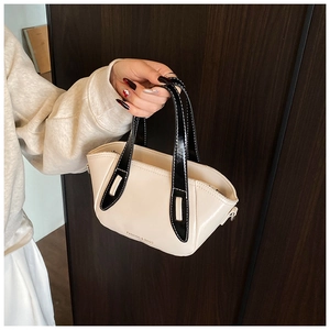 Close-up of cream PU leather bucket bag with black contrast handle and topstitching