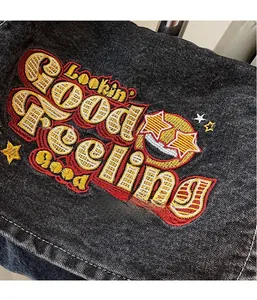 Detailed embroidery on vintage denim tote bag featuring Lookin' Good Feelin' Good slogan